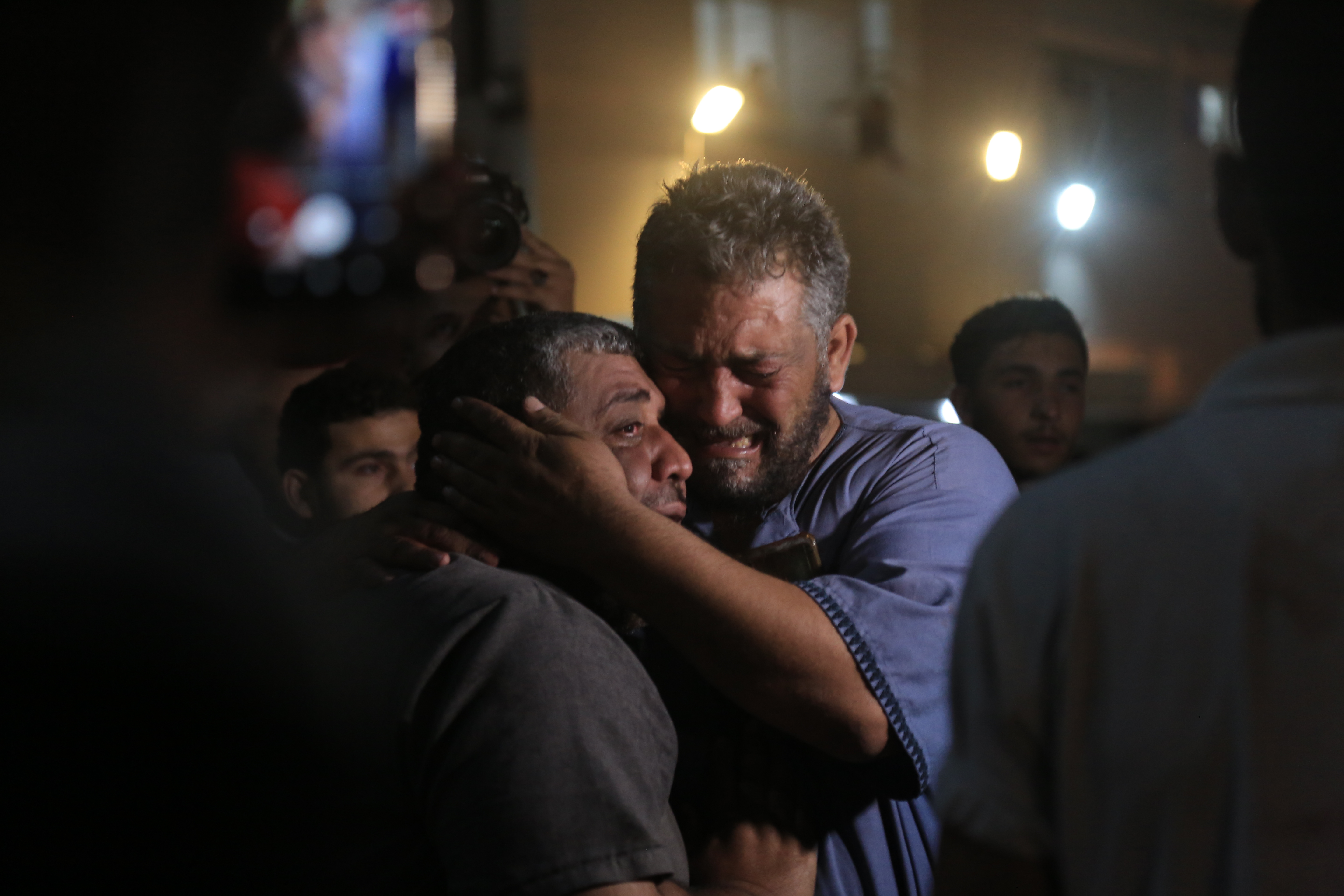 The father and uncle of 12-year-old Yahya Khalifa crying at Al-Shifa Hospital after confirming news of his death. Yahya was killed during an Israeli airstrike on Al-Zaytoun neighbourhood, East of Gaza City. Samar Abu Elouf for the New York Times (2021)